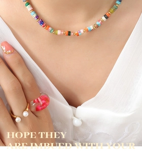 Close-up of bohemian colorful stone beaded necklace and resin ring with dried flowers