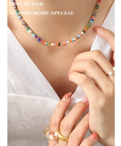 Detail of colorful stone beaded necklace with gold spacers on model neck