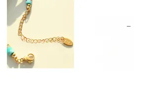 Close-up of K18 engraved metal tag and lobster clasp on a colorful beaded necklace