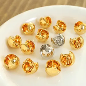 Minimalist copper huggie ball earrings in gold and silver finishes on a ceramic plate