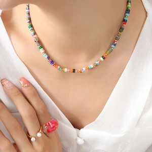 Bohemian colorful stone beaded necklace with gold spacers and stacked rings on a model