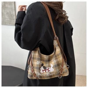 Side view of checkered wool tote bag with cartoon dog print and leather straps