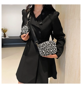 Dettaglio della borsa a tracolla leopardata con una piccola borsa tonda sulla cinghia