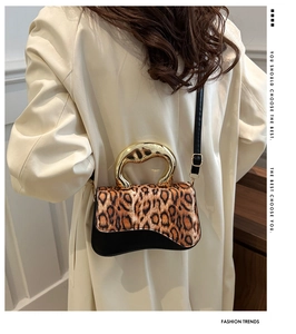 Vintage leopard print handbag with gold metal handle styled with a beige trench coat
