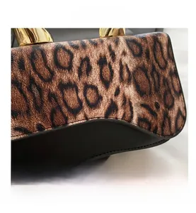 Close-up of leopard print and black leather stitching with gold metal handle detail