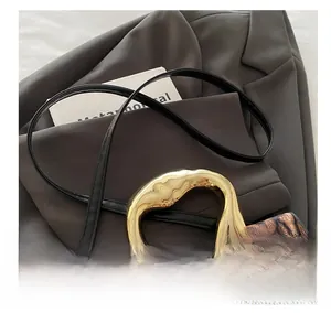 Detail of leopard print crossbody bag with gold handle and adjustable black shoulder strap