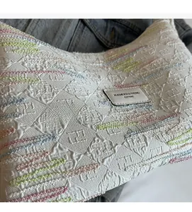 Close-up of textured canvas fabric with colorful stripe embroidery and embossed patterns