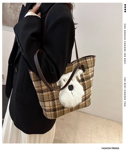 Dettaglio della borsa shopper a quadri con patch in peluche di schnauzer bianco e manici in pelle