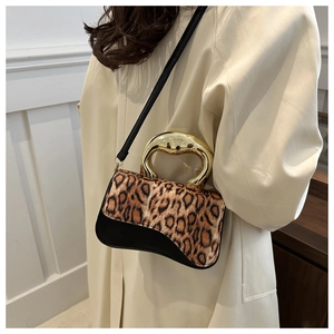 Detail of leopard print crossbody bag featuring a unique thick gold metal top handle