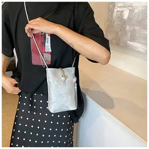 Détail du sac de téléphone argenté avec boucle en perle et long gland élégant à franges