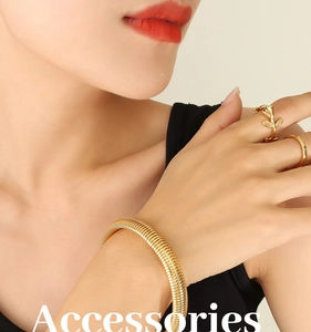 Macro view of wide textured 18k gold plated bracelet and rose ring on female wrist
