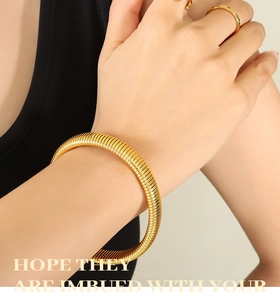 Macro shot of 18k gold plated tubogas bracelet with fine spiral snake bone texture