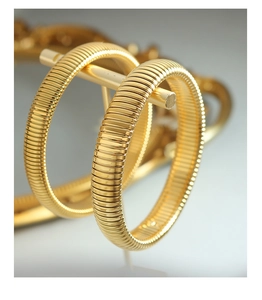 Macro shot of gold Tubogas stretch bracelets with detailed spiral texture and polished finish