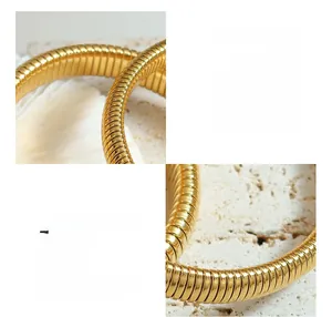 Macro detail of industrial 18k gold plated titanium steel flexible spring bracelet