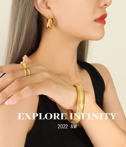 Detail view of 18k gold plated spiral textured bracelet and matching ring on female model