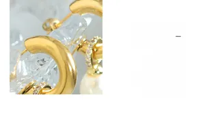 Detail eines C-förmigen Goldohrrings mit Mikropavé-Kristallen und weißer Barockperle