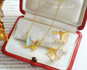 Close-up of elegant butterfly jewelry set with iridescent glass wings in red gift box