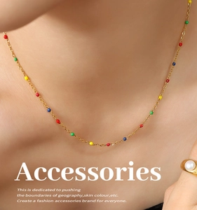 Detail of a gold titanium chain necklace with colorful oil-dripped beads on a model
