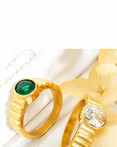 Detail of gold rings with green gemstone, clear zircon and unique vertical texture