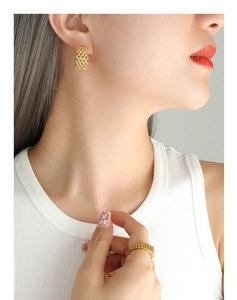 Detail of 18K gold plated mesh C-shaped earrings and matching ring on a model
