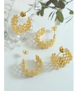 Detail of 18K gold plated titanium C-shape earrings featuring micro-bead mesh texture
