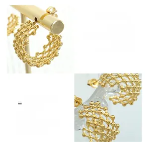 Close-up of titanium steel fishing net C earrings with 18K gold hollow woven texture