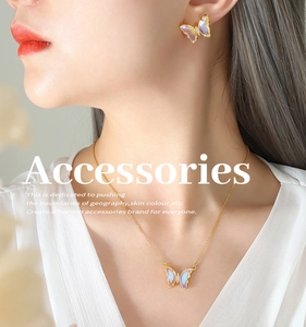 Detailed close-up of a golden butterfly necklace and earrings set worn by a model