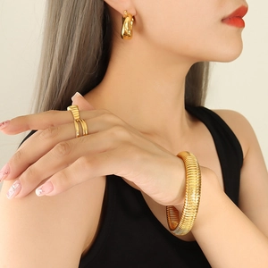 Polished gold titanium steel jewelry set with wide wavy ring and thick textured bracelet