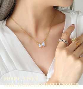 Elegant gold butterfly jewelry set featuring colorful pendants and zircon rings on model