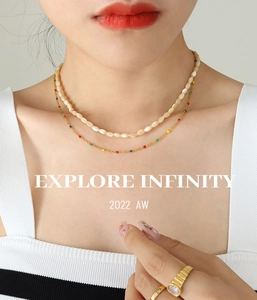 Close-up of layered titanium steel necklace with white shell beads and colorful oil drips