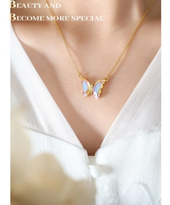 Close-up of elegant golden butterfly necklace with colorful crystal on model neck