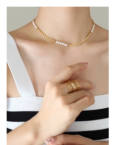 Détail d'un collier en perles d'eau douce avec perles dorées porté par un mannequin
