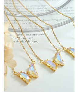 Close-up of iridescent butterfly pendants on gold cross chains in an elegant set