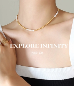Détail du collier ras du cou en perles d'eau douce et perles dorées porté par un mannequin