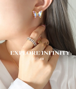 Detail of colorful butterfly earrings and zircon ring jewelry set worn by a model
