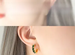 Détail de créoles dorées en C serties de zircons vert émeraude pour femmes chic