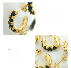 Vue macro de boucles d'oreilles en C en acier titane avec placage or 18 carats et zircon