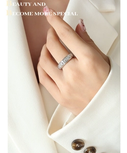 Gros plan sur une bague vintage en argent avec croix en relief et motifs floraux au doigt