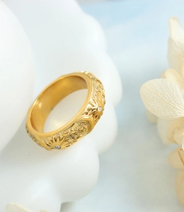 Vue détaillée de la bague céleste dorée avec motifs de soleil et d'étoiles en relief