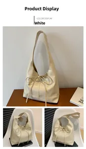Detail view of cream hobo tote bag with delicate bow knot in a cozy home setting