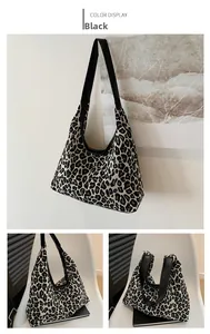Detail of black leopard print hobo tote bag with premium leather straps in home setting