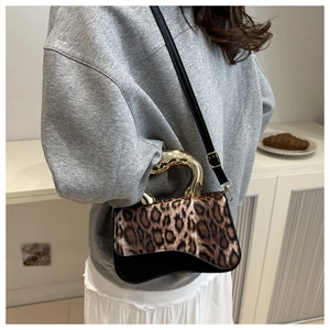 Detail shot of vintage leopard print saddle bag with unique golden sculptural handle