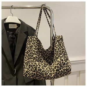 Detailed view of the leopard print canvas tote bag hanging on a metallic hanger