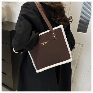Detail of the brown faux leather tote with white plush trim and golden Fanyissa brand logo