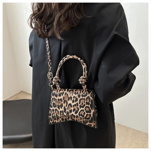 Detail of leopard print hourglass bag with knotted handle and gold metal hardware