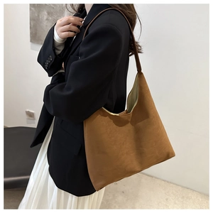 Detail of caramel suede hobo tote bag worn by model, showing its large capacity and texture