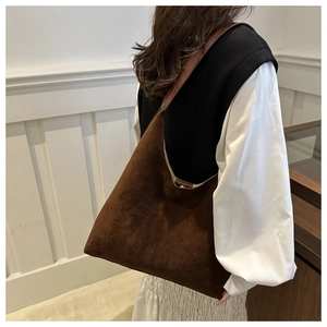 Detailed texture of a dark brown suede hobo bag with sleek leather shoulder strap