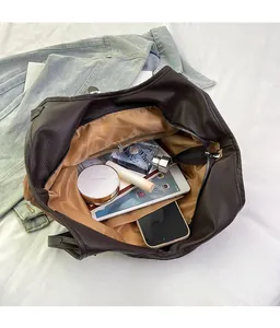 Top-down view of a spacious brown pebbled leather tote bag interior with everyday essentials