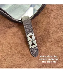 Detail of silver H-shaped buckle on brown suede bag with pebbled leather strap