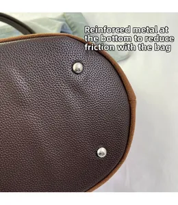 Macro shot of lychee grain leather bag base with silver anti-wear metal studs